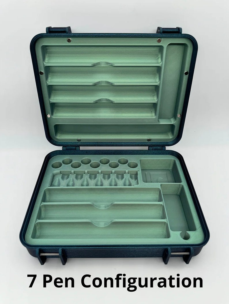 May include: An open blue carrying case with a green interior. The case has multiple compartments for storing pens and other writing instruments. The case is labeled "7 Pen Configuration".