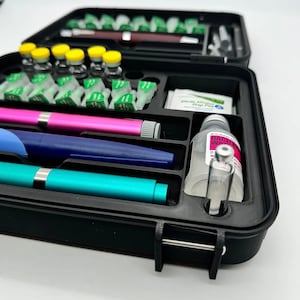 May include: A black plastic case with a variety of medical supplies, including vials, syringes, and a bottle of antibacterial wash. The case has a latch to keep it closed.