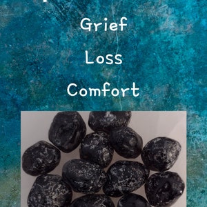 May include: A collection of black Apache Tears stones, also known as obsidian, on a white surface. The stones are smooth and have a shiny, glassy appearance. Apache Tears are believed to be a stone of comfort and healing, and are often used in meditation and healing practices.