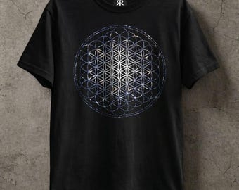 May include: A black short-sleeved t-shirt featuring a large, circular geometric pattern known as the flower of life. The design is composed of overlapping circles in shades of white, blue, and silver, creating a complex, symmetrical, and intricate grid.