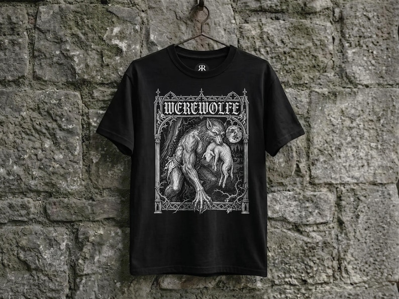 Black shirt hanging on a rustic hanger against a weathered stone wall, featuring a detailed gothic illustration of a werewolf beneath a full moon, framed by medieval cathedral-inspired architecture and rendered in a vintage engraving style.