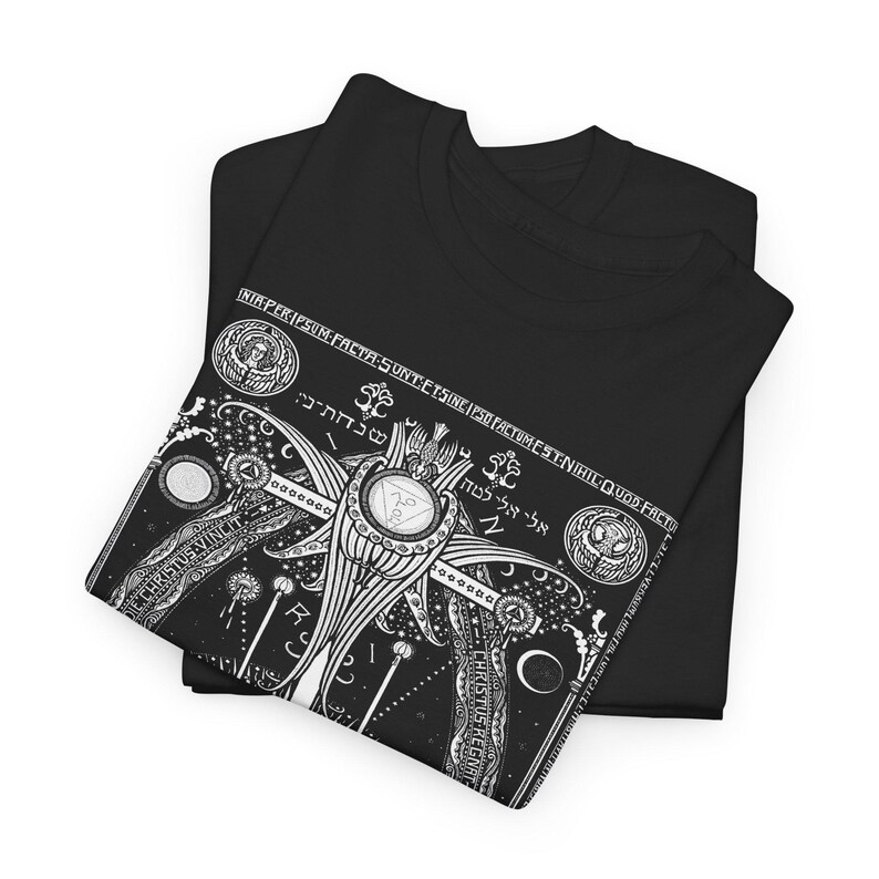 May include: Black t-shirt with a white graphic print of a complex design featuring a winged figure, geometric shapes, and text in Hebrew. The design includes the words "INIAPER-IPSUM FACTA SUNT ETSINE IPSO FACTUMEST-N", "CHRISTUS", "שנחת-ני:", "אלי אלי לטה", and "QUOD FACTU".