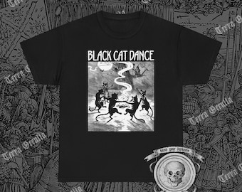Könnte beinhalten: Schwarzes T-Shirt mit einer Schwarz-Weiß-Illustration von tanzenden Katzen unter einem Vollmond. Der Text "BLACK CAT DANCE" ist über der Grafik aufgedruckt. Das Shirt hat einen Rundhalsausschnitt und kurze Ärmel.