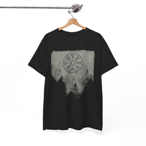 Może przedstawiać: Czarny T-shirt z szarym akwarelowym wzorem lasu z kompasem w środku. Kompas ma runy wok&oacute;ł krawędzi.