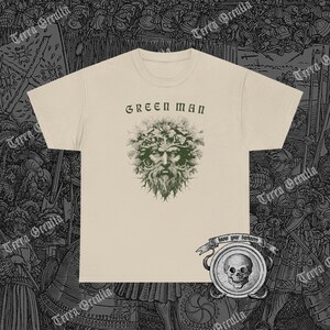 May include: A beige t-shirt with a green man graphic and the text "GREEN MAN" printed on the front. The graphic features a man's face with leaves and branches for hair. Below the graphic is a small banner with the text "know your darkness".