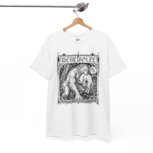 May include: A white short-sleeve t-shirt featuring a black and white graphic print of a werewolf holding a lamb within an ornate gothic archway. The text WEREWOLFE is printed in a stylized gothic font at the top of the rectangular illustration.