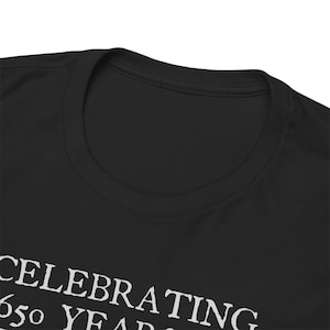 Puede incluir: Camiseta negra con texto blanco que dice "Celebrating 650 Years".