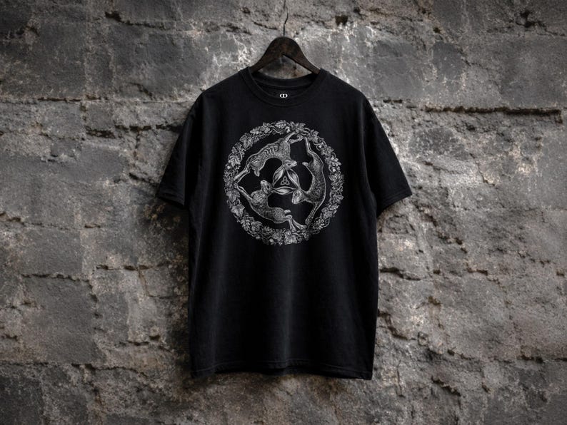 Black t-shirt featuring the Three Hares symbol with three rabbits arranged in a circular pattern around a central triquetra knot, inspired by pagan symbolism, Celtic folklore, fertility motifs, and medieval sacred art.
