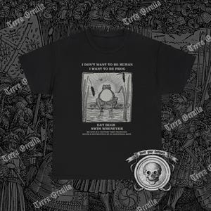 May include: Black t-shirt with a white graphic of a frog sitting on a lily pad. The text reads "I don't want to be human I want to be frog Eat bugs Swim whenever We live in a factory that produces death & destruction at an industrial rate".