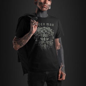 May include: A black t-shirt with a green man graphic and the text "Green Man" printed on the front.