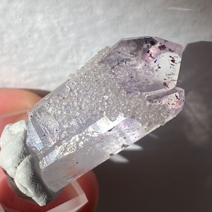 Stellar twin Goboboseb amethyst with analcime jacket, harlequin effect, hematite flecks, unique ghostly matte tip, optical clarity