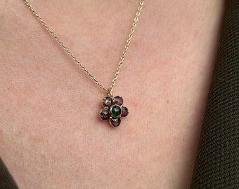 18k gold pendant in the shape of a flower with garnets and green tourmaline