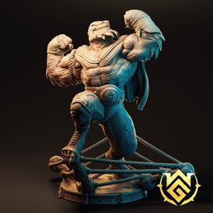 Peut inclure: Une figurine détaillée en gris, imprimée en 3D, représentant une créature reptilienne musclée portant une cape et un équipement de lutte. La créature est en position de combat, un bras levé et l'autre serré en poing. La figurine est posée sur une base avec des cordes, suggérant un ring de lutte.