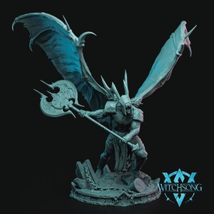 May include: A gray, detailed miniature figurine of a demon with large wings, holding a double-headed axe. The figurine is standing on a circular base with chains and a stone texture. The base has the text "WITCHSONG" on it.