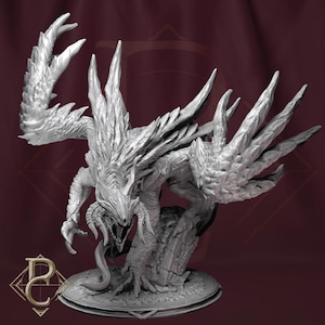 May include: A detailed, gray fantasy creature sculpture with large, clawed hands and wings. The creature has an open mouth with visible teeth and is posed on a circular base. The sculpture has a textured, detailed surface.