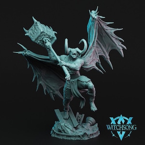 May include: A gray, detailed miniature figurine of a demon with horns, wings, and a large hammer. The demon is posed in mid-air, with its wings spread wide. The figurine is set on a base with a rocky texture. The text "WITCHSONG" is visible in the lower right corner of the image.