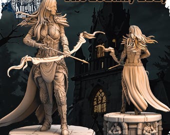 May include: Two detailed miniature figures of women, one holding a bow and arrow and the other holding a staff, standing on stone bases. The figures are painted in a light beige color and are set against a dark background. The text "The Loathly Lady" is visible at the top of the image.