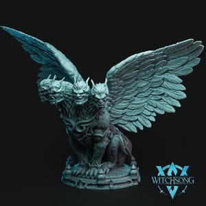 May include: A three-headed winged creature with a fierce expression, sculpted in a light grey colour. The creature is perched on a circular base with intricate details. The sculpture is labelled "Witchsong" in the bottom right corner.