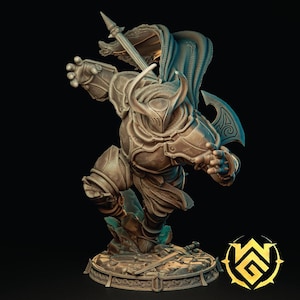 Puede incluir: Una figura en miniatura detallada de un guerrero con armadura completa, sosteniendo una lanza y un hacha de batalla. La figura está pintada en color bronce y se encuentra sobre una base rocosa.