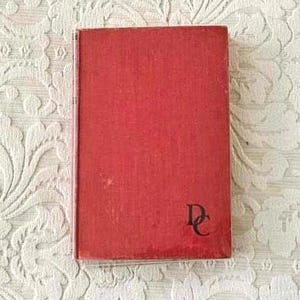 May include: A red hardcover book with the letter "D" and "C" in black on the front cover.