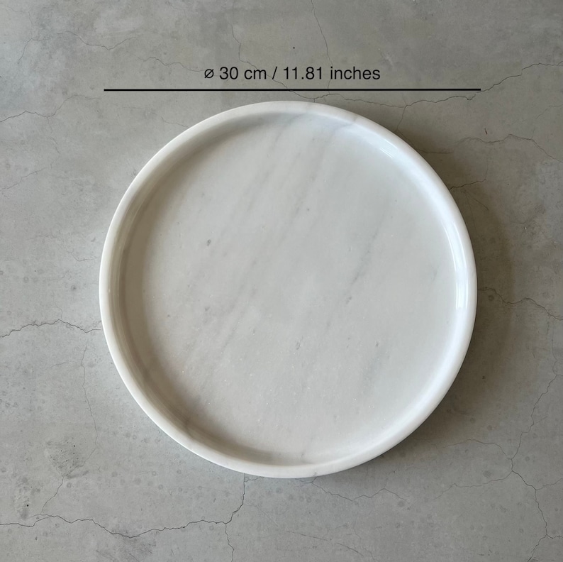 Pode incluir: Bandeja redonda de m&aacute;rmore branco, di&acirc;metro 30 cm.