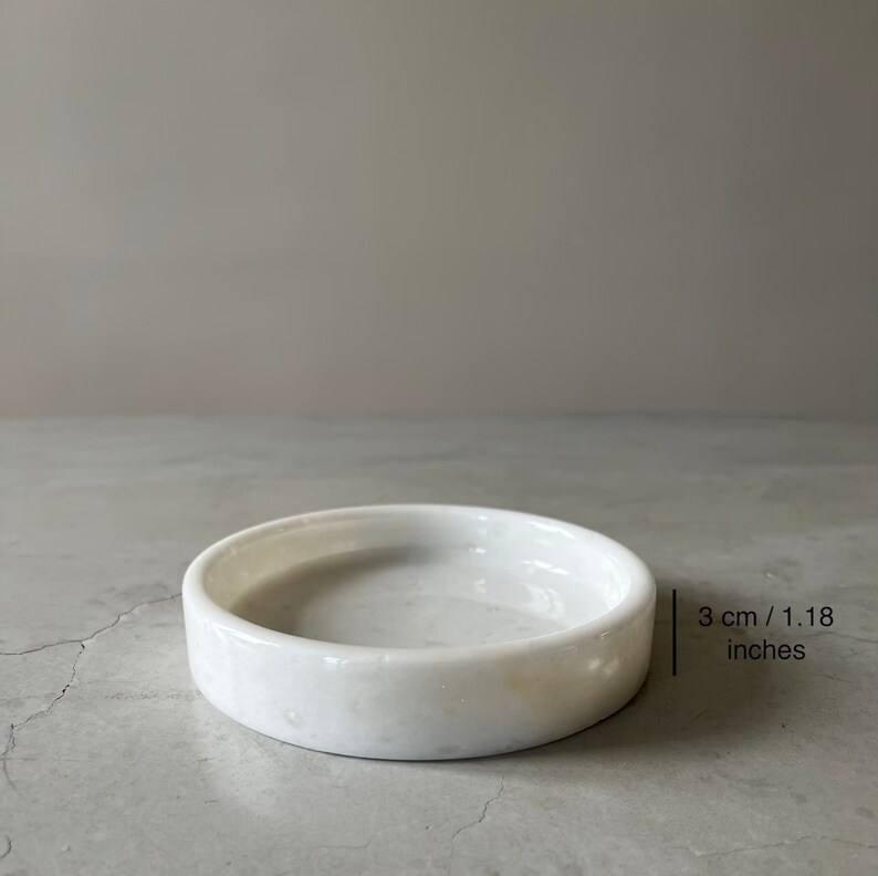 Pode incluir: Prato de m&aacute;rmore branco para bijuterias, com 3 cm de di&acirc;metro.