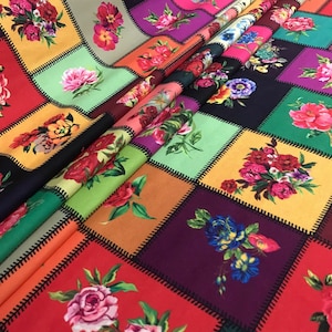 May include: A colorful fabric with a patchwork design featuring floral patterns. The squares are in various colors, including red, orange, green, and purple, with black stitching. The floral designs include roses and other flowers.
