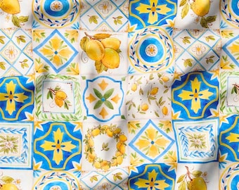 Könnte beinhalten: Ein weißer Stoff mit einem sich wiederholenden Muster aus blauen und gelben Fliesen. Die Fliesen zeigen Blumenmuster, geometrische Formen und Zitronen.