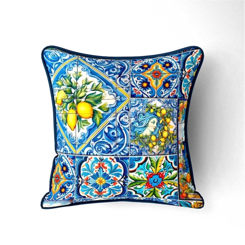 May include: A blue and yellow throw pillow with a colorful tile pattern featuring lemons, flowers, and a woman's face.