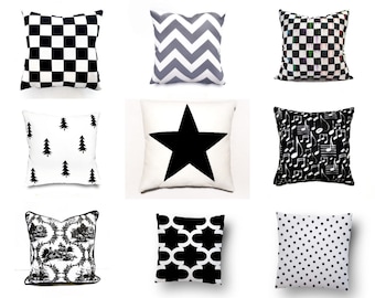 Könnte beinhalten: Neun schwarze und weiße Kissen mit verschiedenen geometrischen Mustern. Die Muster umfassen Karos, Zickzack, Sterne, Noten, Blumen und Punkte.