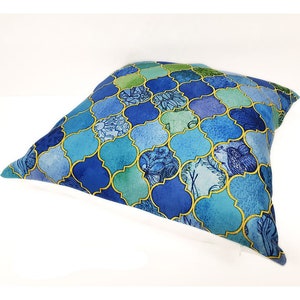 Peut inclure: Un coussin bleu et vert &agrave; motif g&eacute;om&eacute;trique. Le coussin a une bordure blanche et une fermeture &eacute;clair.