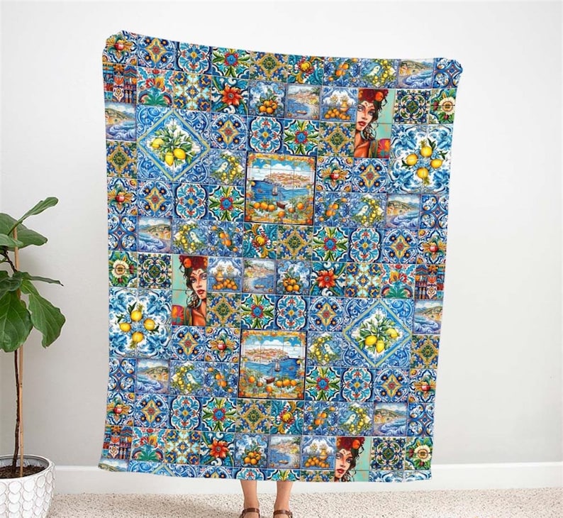 May include: A blue and white throw blanket with a colorful pattern of lemons, flowers, and geometric designs. The pattern is reminiscent of traditional Portuguese tiles.