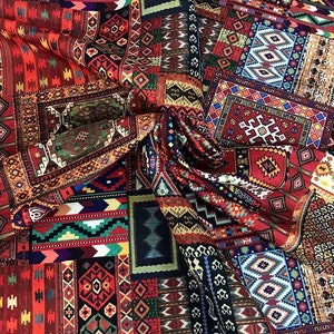 May include: A vibrant textile featuring a patchwork design of various rug patterns. The fabric showcases a rich palette of reds, blues, greens, and golds, with intricate geometric and floral motifs. The overall effect is a display of traditional rug artistry.