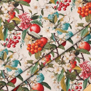 May include: A white fabric with a repeating pattern of red and orange berries, green leaves, and white flowers. The fabric is folded in half, showing the pattern on both sides.