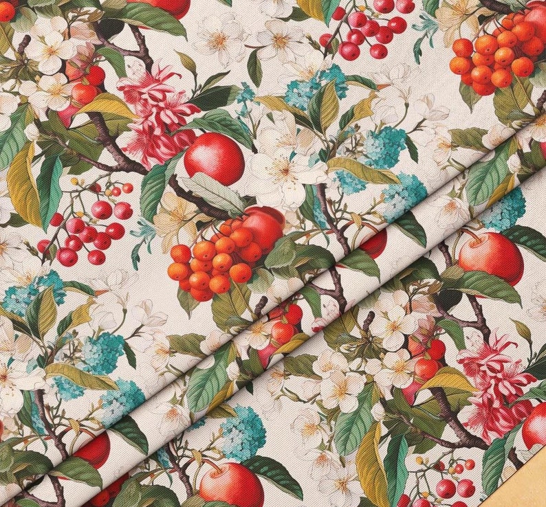 May include: A white fabric with a repeating pattern of red and orange berries, green leaves, and white flowers. The fabric is folded in half, showing the pattern on both sides.