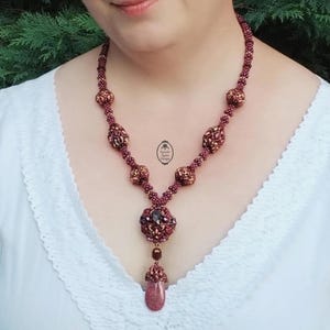 May include: A white ceramic mug with a black handle and the text "But First, Coffee" in a bold, black font. The mug is set against a blurred background, suggesting a cozy setting.