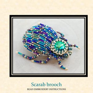 May include: A beaded scarab brooch with a vibrant design. The brooch features a central emerald-green gemstone, surrounded by a beaded body in shades of blue, teal, and purple. The text "Scarab brooch" and "BEAD EMBROIDERY INSTRUCTIONS" are displayed.
