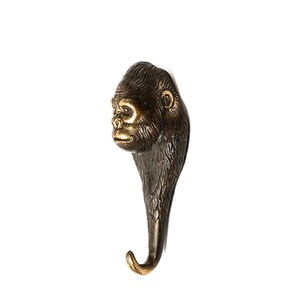 May include: A bronze gorilla head hook with a gold finish. The hook is shaped like a gorilla's head with a long, curved neck.
