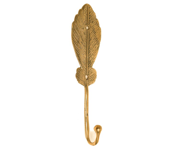 May include: A gold leaf-shaped hook with a decorative design. The hook is made of metal and has a smooth finish.