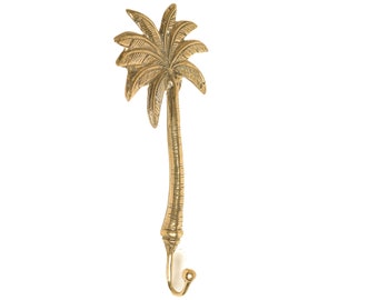 Puede incluir: Un gancho de metal dorado con forma de palmera. El gancho está hecho de metal y tiene un diseño detallado de palmera.