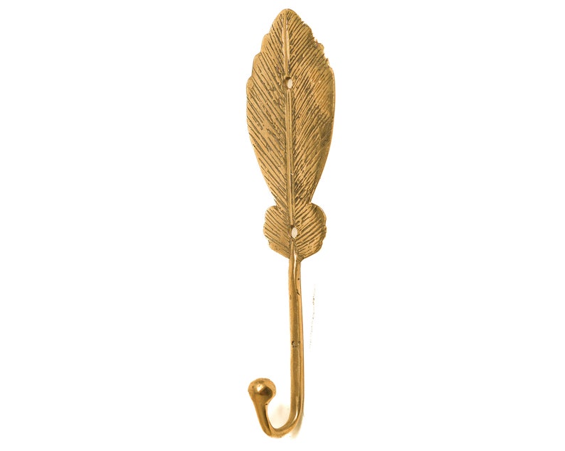 May include: A gold leaf-shaped hook with a decorative design. The hook is made of metal and has a smooth finish.