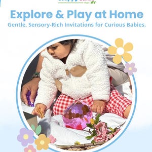 May include: A book cover with the title "Explore & Play at Home" and the Happy Kids logo. The image features a baby in a white jacket and red checkered pants playing with toys. The text reads "Gentle, Sensory-Rich Invitations for Curious Babies."