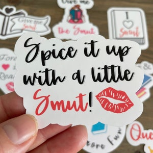 Op de afbeelding: Witte sticker met een rode lipafdruk en zwarte tekst die "Spice it up with a little Smut!" luidt.
