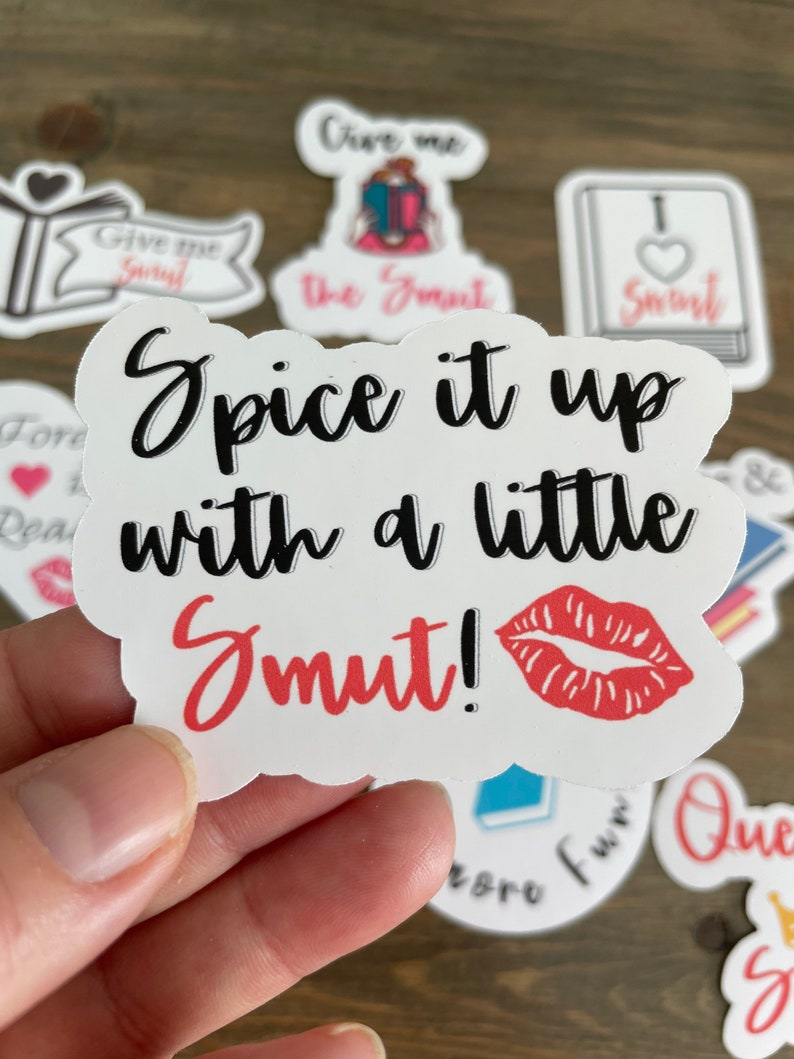 Op de afbeelding: Witte sticker met een rode lipafdruk en zwarte tekst die "Spice it up with a little Smut!" luidt.
