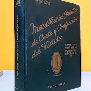 May include: A vintage book titled "Método Teórico-Práctico de Corte y Confección del Vestido" in dark teal with gold lettering. The cover features an illustration of a woman in a dress and the text "Buenos Aires".