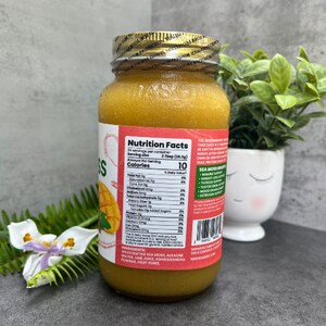 Pu&ograve; includere: Un barattolo di vetro di succo di mango giallo con un'etichetta rossa che dice "Nutrition Facts" e elenca gli ingredienti: Alghe marine selvatiche, acqua alcalina, succo di lime, polvere di ashwagandha, purea di frutta.