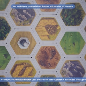 May include: A collection of hexagonal board game tiles featuring illustrations of forests, mountains, fields, and pastures. The tiles are arranged in a grid pattern. Text on the image states: and backwards compatible to fit older edition tiles up to 80mm, and this means you could mix and match your old and new sets together in a seamless looking board!