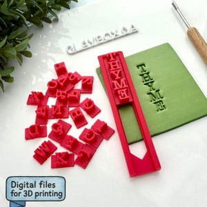 May include: A collection of red letter stamps and a red stamp holder with the word "THYME" printed on it. A green block has the word "THYME" stamped on it. The text "Digital files for 3D printing" is in a blue box.