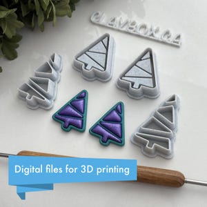 May include: Five 3D printed Christmas tree cookie cutters. The cutters are white and have a geometric design. Two smaller purple and teal Christmas trees are also shown. The text "Digital files for 3D printing" is visible at the bottom of the image.