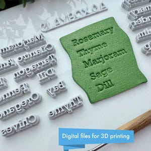 Puede incluir: Un conjunto de sellos de letras grises impresos en 3D y un sello verde texturizado con los nombres de hierbas: Romero, Tomillo, Mejorana, Salvia y Eneldo. La imagen tambi&eacute;n incluye el texto "Digital files for 3D printing".